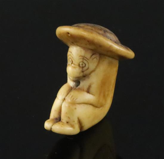 An 18th century Japanese stag horn netsuke of a monkey wearing a broad rimmed hat, depth 4cm height 4.75cm